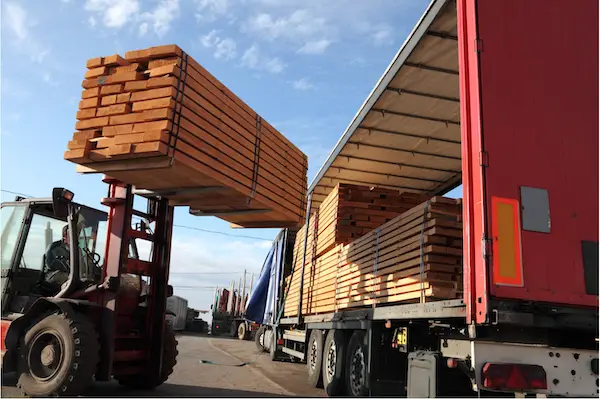 a truck with a forklift loading wood