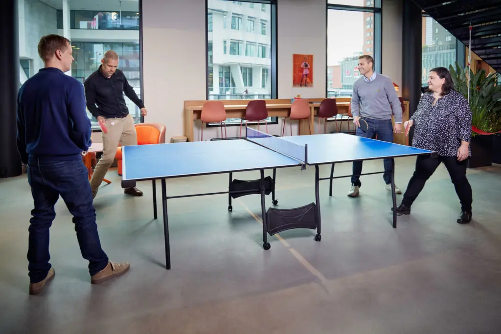 a group of people playing ping pong