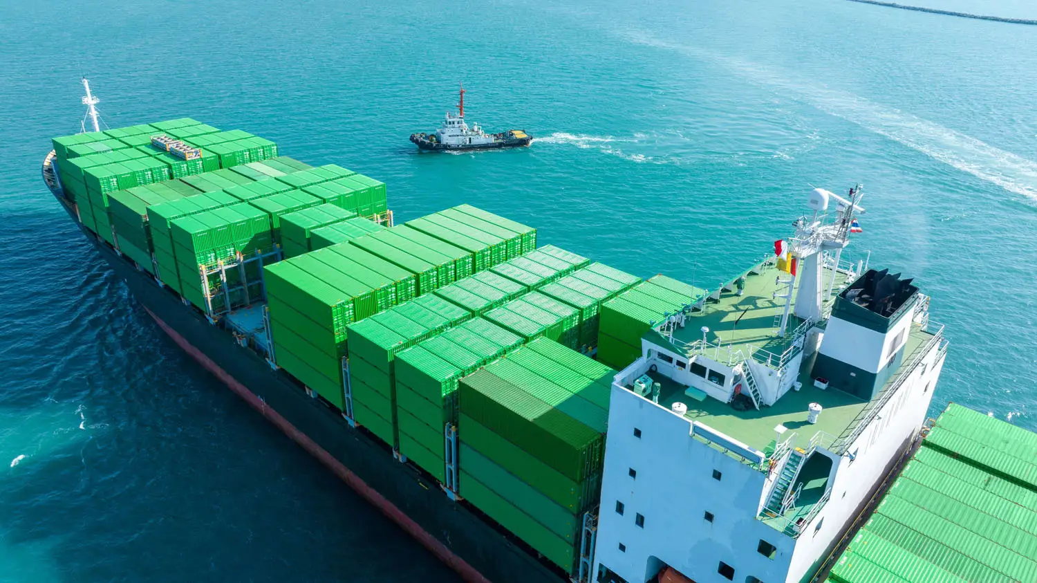 Transport sustainability reporting - a large container ship with green containers on the water